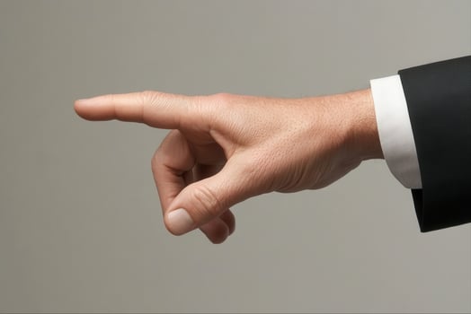 Elegant hand gesture in business attire signaling direction against a neutral background photo