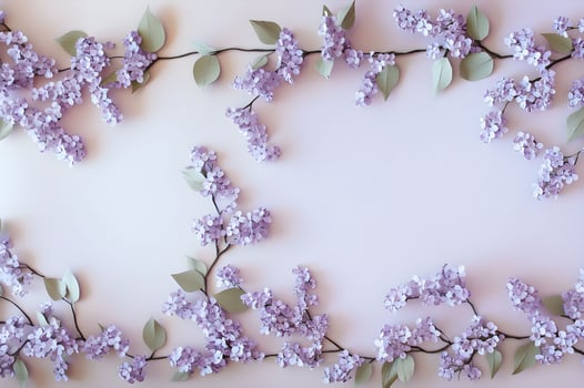 Frame of delicate lilac branches and flowers on a pastel background photo