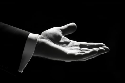 Elegant outstretched hand in formal attire against a dramatic black background photo