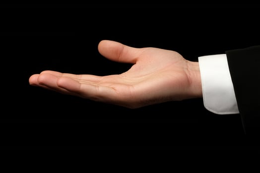 Open hand gesture against a black background, symbolizing invitation or offering photo