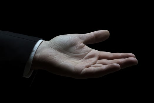 Open hand gesture in a dark setting, symbolizing invitation or offering, with subtle elegance photo