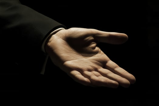 Open hand reaching out in a dramatic light setting, symbolizing invitation or help photo