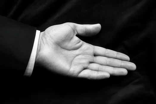 Open hand of a business professional against a dark background, symbolizing readiness photo