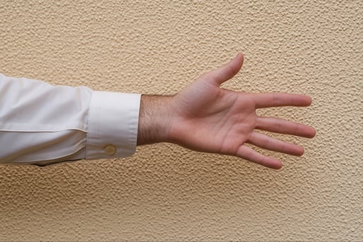 Outstretched hand against a textured wall, symbolizing invitation or greeting gesture photo
