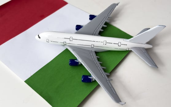 Travel flight to Italy concept. Toy airplane model and Italy flag photo
