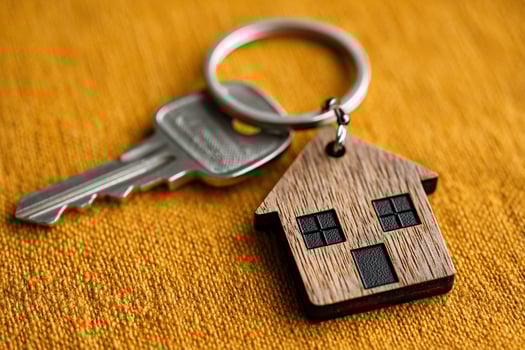 Home Keychain. Silver key with wooden house keychain photo