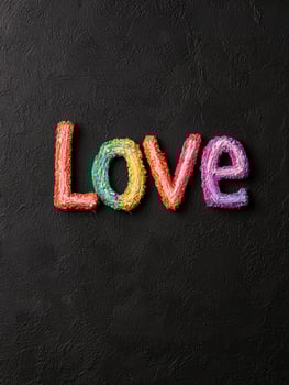 Colorful stitched Love text on a textured black background photo