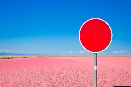 Vibrant Red Stop Sign Against a Stunning Pink Salt Flat Under a Bright Blue Sky Creating a Striking Contrast Between Colors and Landscapes photo