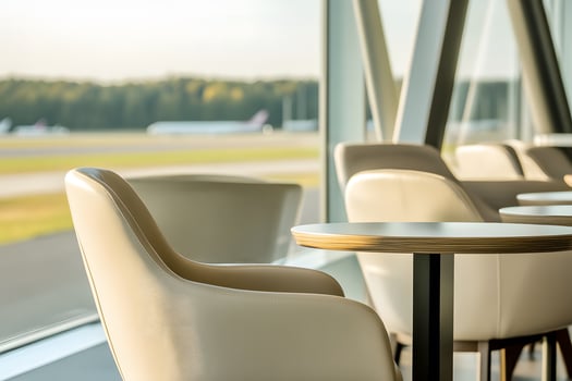 Modern Lounge Area with Stylish Seating Overlooking Airport Runway and Aircraft, Inviting Atmosphere for Travelers and Relaxation in a Bright, Airy Space photo