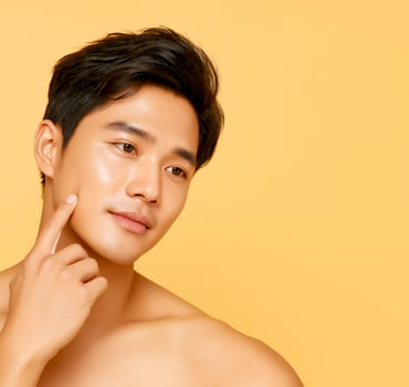 Handsome asian man with long short hair over colorful background. Beauty and healthy lifestyle. Yellow cream background. photo