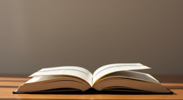 An open book on a table with sunlight streaming in photo