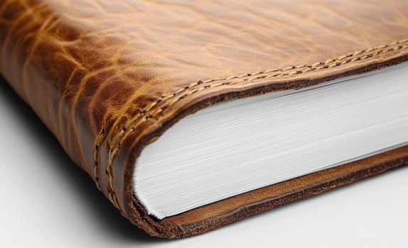 Textured leather journal. A close-up view of a leather-bound journal showcasing its textured cover and crisp, white pages ready for writing. photo