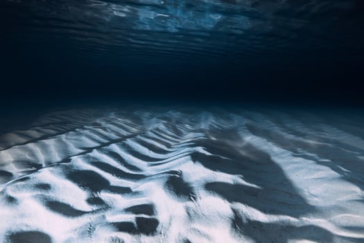 Sand ripples on ocean floor create a serene and abstract underwater seascape photo