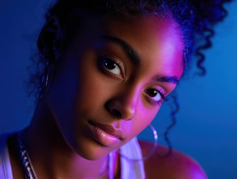Portrait of a young woman in colorful lighting showcasing confidence and style photo