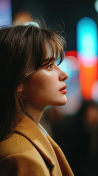 Woman gazing thoughtfully under vibrant city lights at night in urban setting photo