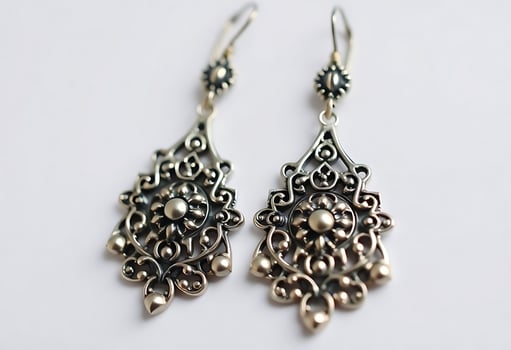 pair of silver earrings on a white surface photo