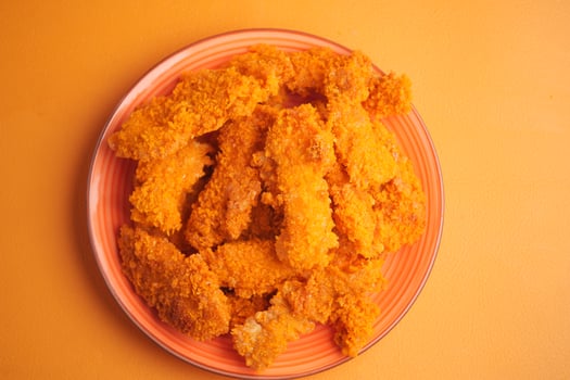 Delicious golden fried chicken strips served on a colorful plate photo