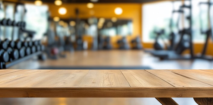 Rustic wooden tabletop with blurred background of modern gym, perfect setting for showcasing fitness products or healthy lifestyle concepts. Fitness display concept photo