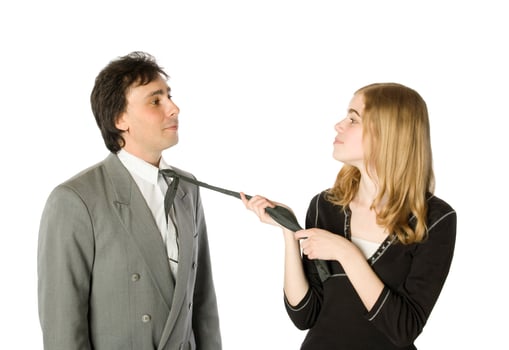 Young woman pulling a man by a necktie photo