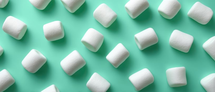Delicate arrangement of white marshmallows on mint background food photography minimalist style photo