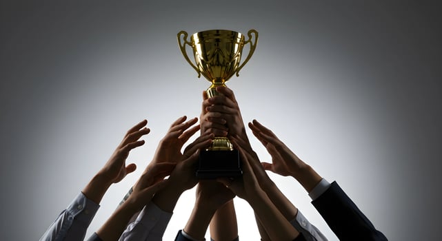 Golden Trophy Is Raised by Hands photo