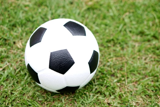 Football, classic black and white soccer ball placed on a green grass field, represents one of the most iconic pieces of sports equipment used in matches training and recreational play worldwide. photo