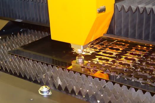 CNC laser cutting machine cutting metal with sparks photo