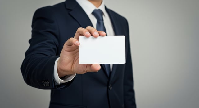 Businessman in suit holds blank white card. Professional presents empty business card for message, contact information, or marketing. Mockup template for design. photo