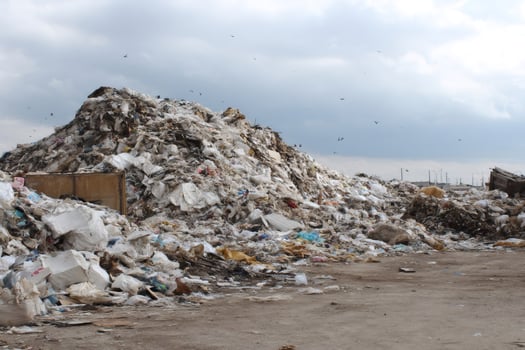 Huge pile of garbage polluting the environment under cloudy sky photo