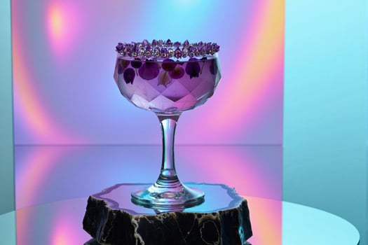 A purple glass with purple crystals on top photo