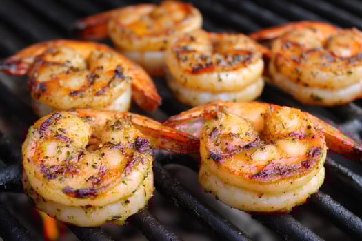 Grilled shrimps cooking on barbecue grill with flames photo
