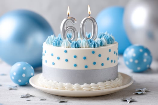 Celebration cake decorated with blue frosting, silver ribbon, and candles, surrounded by balloons and stars, perfect for a milestone birthday party or special occasion photo