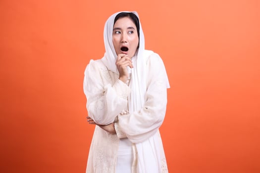 Astonished gaze of a modern muslim woman, expressing shock with photo