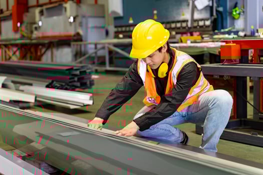 Engineering technician worker measuring the steel from metal sheet forming machine inside the manufacturing factory for line production and industry photo
