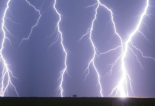 large group of lightning strikes over a field photo