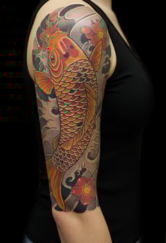 Arm Tattoo with Ornamental Fish and Flower Design photo