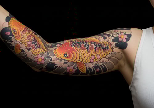 Arm Tattoo with Swimming Koi Fish and Cherry Blossoms photo