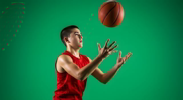 A young man in a red shirt is throwing a basketball photo