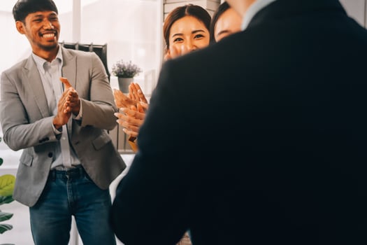 A group of people clapping in an office photo