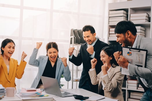 A group of business people celebrating in an office photo