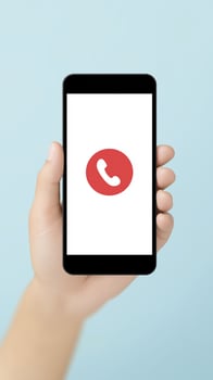 Hand holding a smartphone with a red phone icon on screen photo