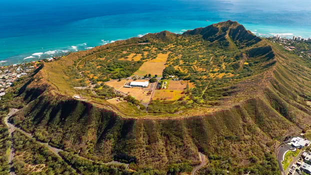 Distancing from Diamond Head Crater in Honolulu, Hawaii, USA. Scenic view on the city at the backdrop of azure waterscape. Aerial view. photo