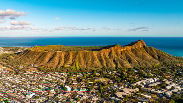Rugged slopes of Diamond Head Crater are lit with bright sun. Cityscape of Honolulu around the rock. Aerial view. photo