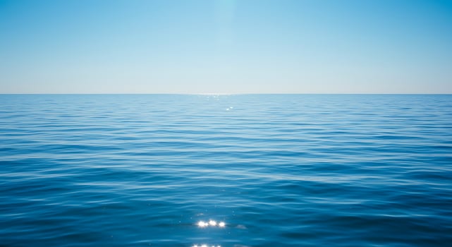 A view of the ocean with a bright sun shining over it photo