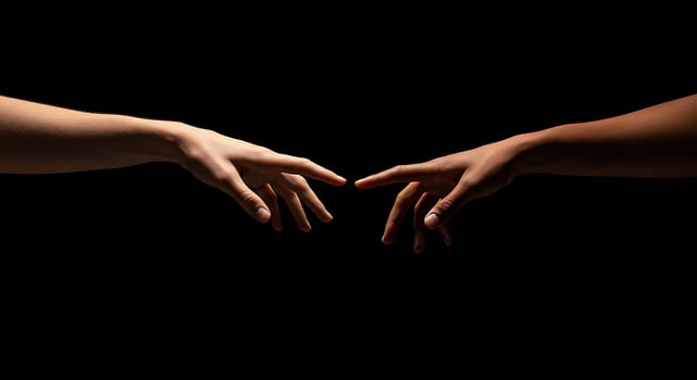 Two hands reaching out to each other on a black background photo