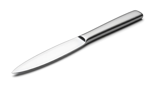 A knife is shown on a white surface photo