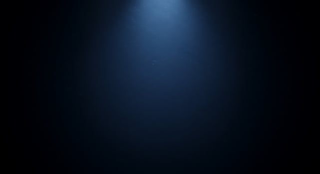A blue light shines through the dark background photo