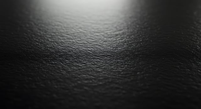 A black surface with a light shining on it photo