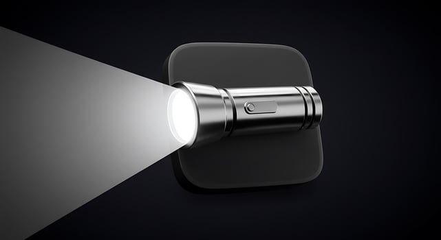 A flashlight is shining on a black surface photo