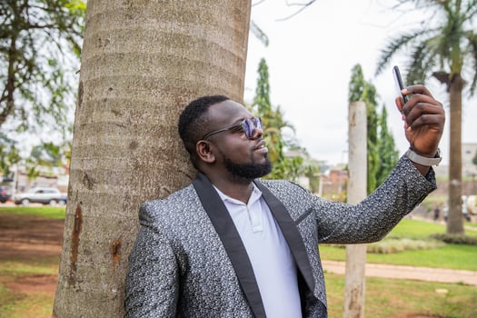 An African businessman makes a call with his smartphone while outdoors photo